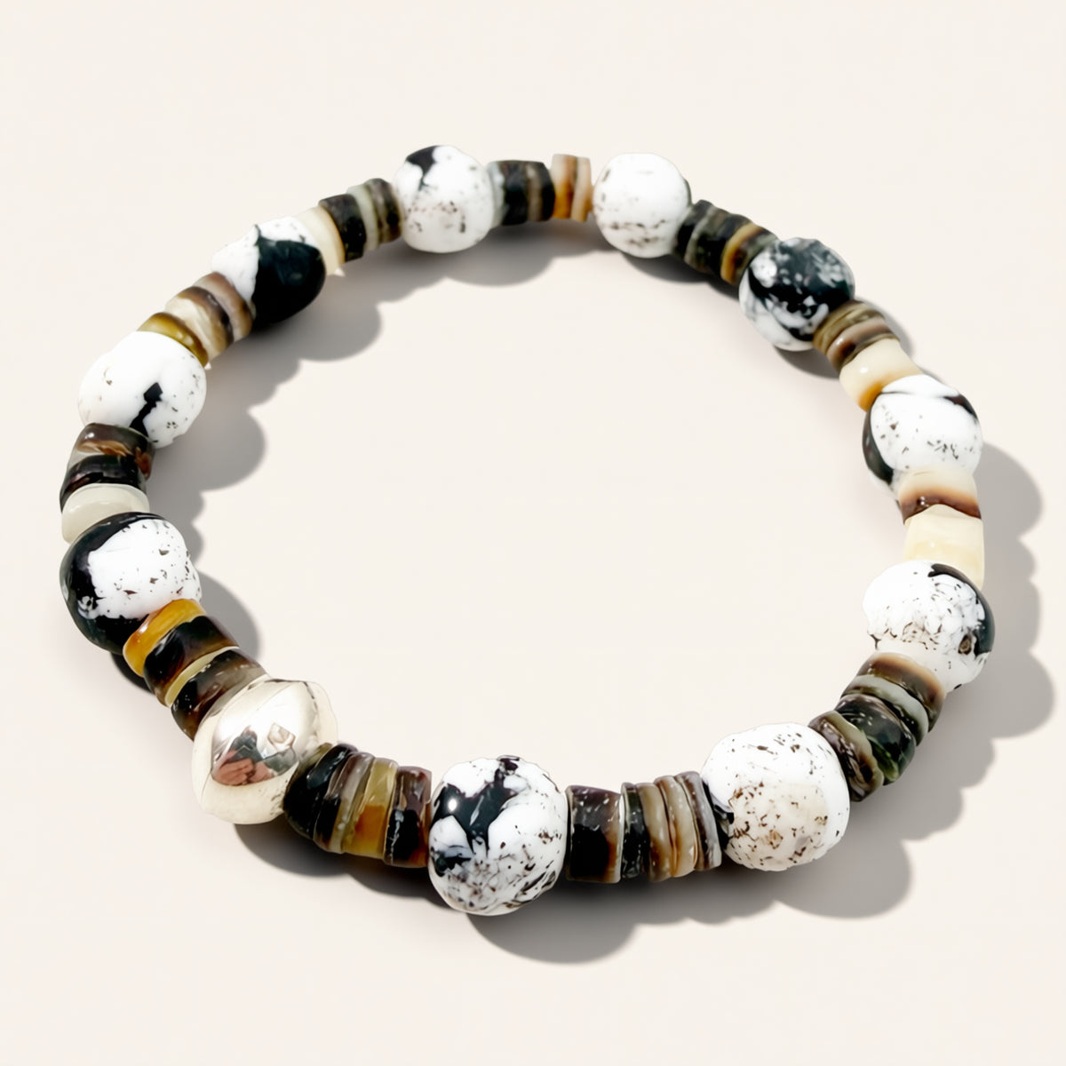 Beaded bracelet with black, white, and brown beads on a light background