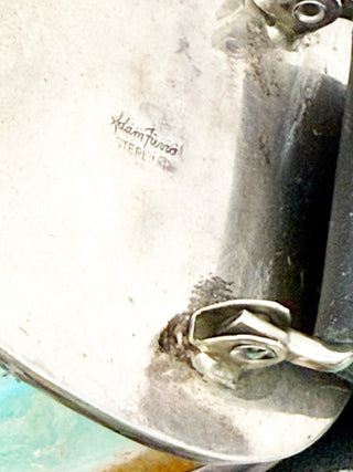 Close-up of a metal jewelry branding on a white background