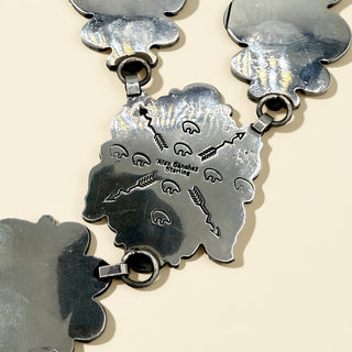 Close-up of a silver jewelry with engraved designs on a beige background