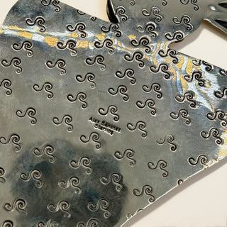 Silver pendant back with stamp of 'Alex Sanchez' branding.