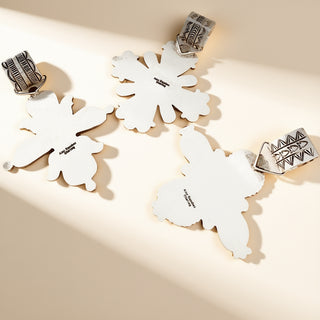 Silver stamp pendants on a beige background