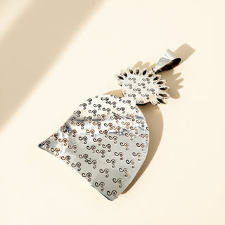 Silver stamp pendant on a beige background