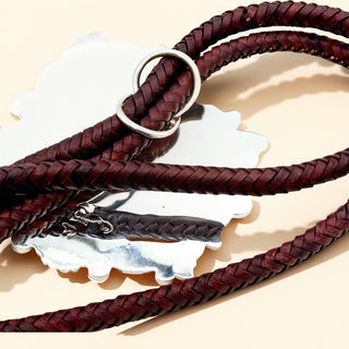 Brown rope and silver pendant on a beige background