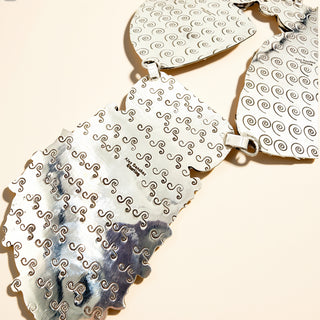 Silver stamp necklace on a beige background