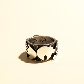 Decorative ring with intricate designs on a beige background