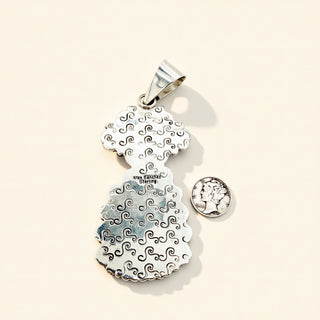 Silver pendant with wave pattern on a beige background