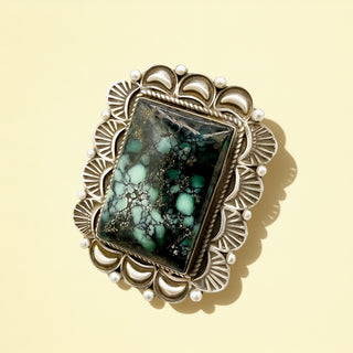 Silver ring with turquoise stone on a beige background