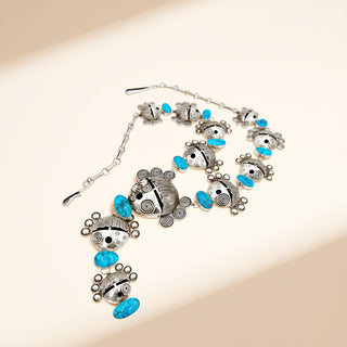 Necklace with silver and turquoise beads on a beige background