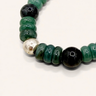 Green and black beaded bracelet on a white background