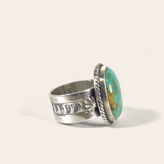 Silver ring with turquoise stone on a light gray background