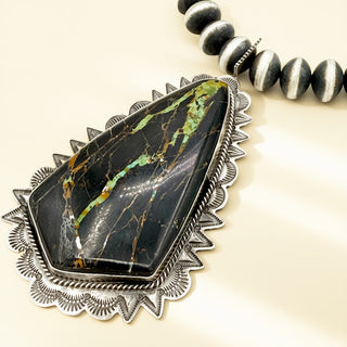 Black stone pendant on a beige background