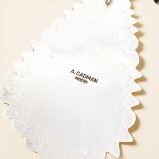 Silver stamp pendant on a beige background