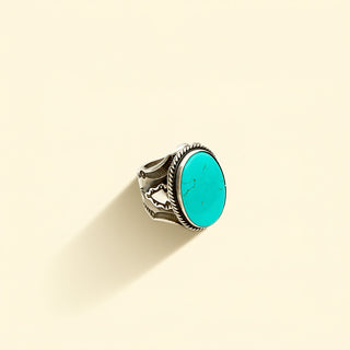 Silver ring with turquoise stone on a beige background