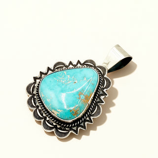 Turquoise pendant against a beige background
