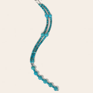 Turquoise beaded necklace on a light beige background