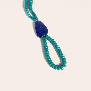Necklace with blue pendant and turquoise beads on a white background