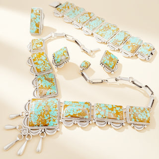 Jewelry set with turquoise and gold stones on a beige background