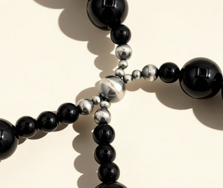 Close-up of black and silver beaded bracelet on a light background