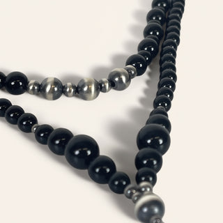 Two black beaded necklaces on a white background
