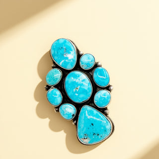 Turquoise cluster ring on a beige background