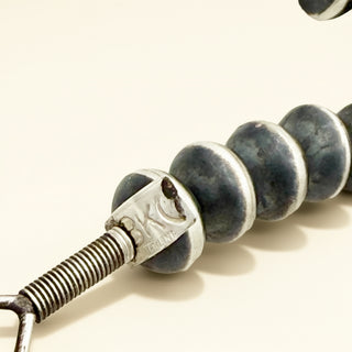 Close up of black pearls with stamp on a beige background