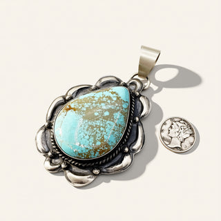 Turquoise pendant with silver frame on a white background