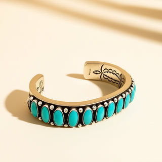 Silver bracelet with turquoise stones on a beige background