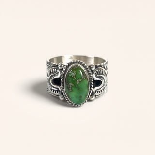 Silver ring with a green stone on a white background