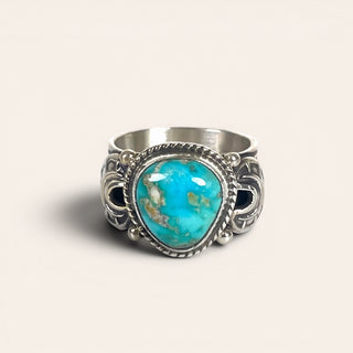 Silver ring with a turquoise stone on a light background