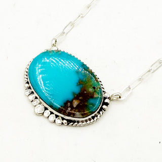 Oval Turquoise pendant necklace on a white background with silver detailing