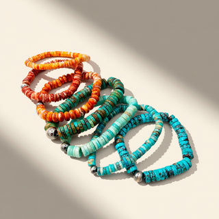 Colorful beaded bracelets on a beige background