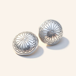 Pair of silver earrings with intricate designs on a white background