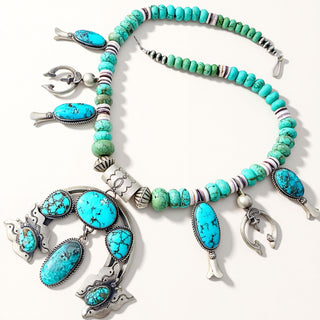 A turquoise and silver Southwestern-style jewelry set, including a beaded necklace, a large matching pendant, and two matching earrings, displayed on a clean white background.
