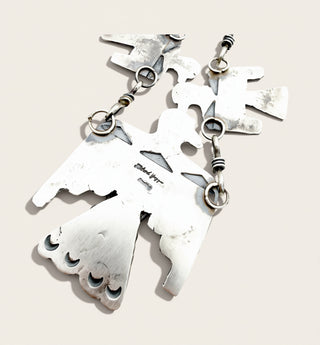 The back of a silver bird attached to a chain with the name Richard Yazza