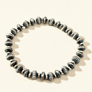 Silver beaded bracelet on a light background