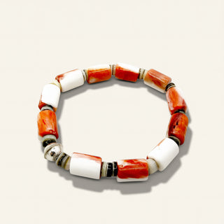 Bracelet with orange and white beads on a beige background