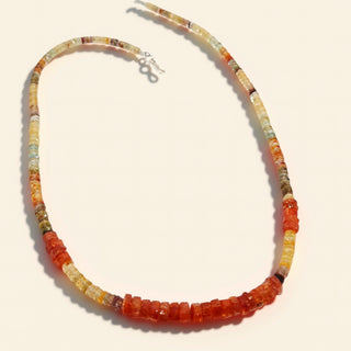 Orange beaded necklace one a beige background