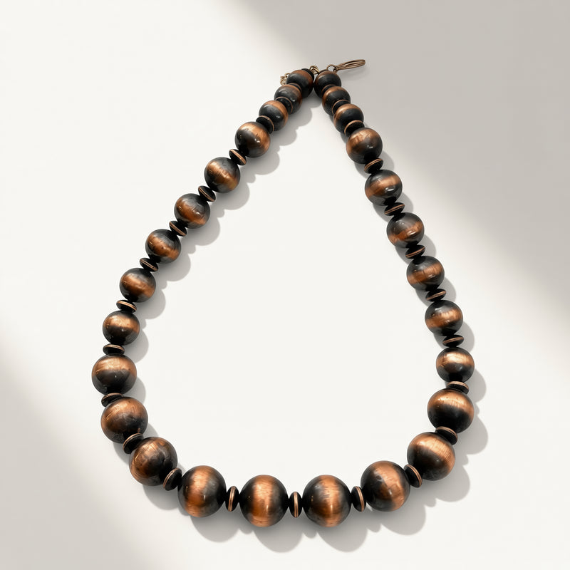 copper beaded necklace on a light gray background