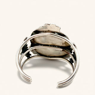 Silver ring with a central stone on a white background