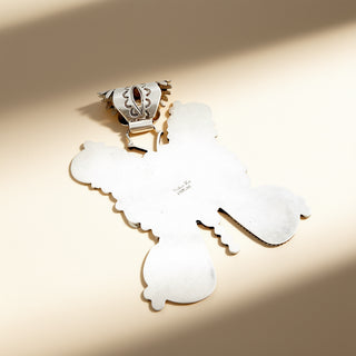 Silver pendant with stamp on a beige background