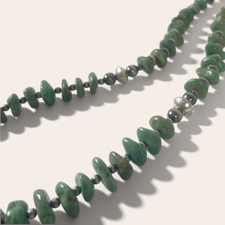 Necklace with green and gray beads on a white background