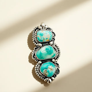 Turquoise stone pendant with silver frame on beige background