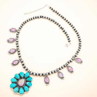 Necklace with pearls and turquoise flower pendant on a rose background