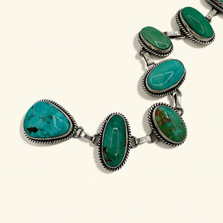 Turquoise stone t with silver accents on a white background