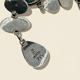 Close-up of a silver jewelry  with engraved text on a beige background