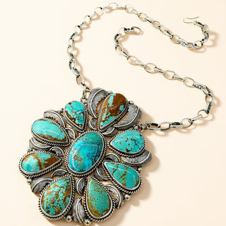Turquoise stone necklace with silver chain on a beige background