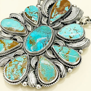 Turquoise stone and silver jewelry on a beige background