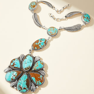 Necklace with turquoise and brown stone pendants on a beige background