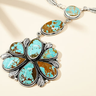 Necklace with turquoise stones and silver accents on a beige background