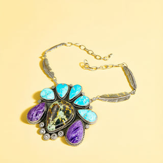 Silver necklace with multi-color stones on a beige background